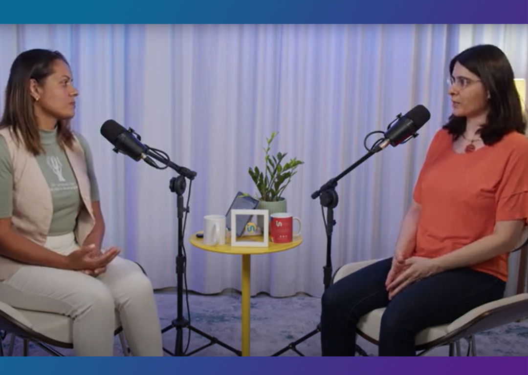 Vânia Ferreira entrevista Cláudia Nascimento. Ambas estão sentadas em frente à microfones.